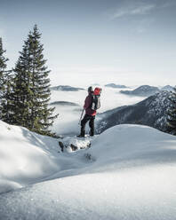 Deutschland, Bayern, Ammergauer Alpen, Teufelstattkopf, Tourist beim Bergwandern an einem Wintertag - RBF08062