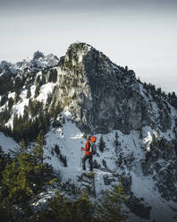 Deutschland, Bayern, Ammergauer Alpen, Teufelstattkopf, Tourist beim Bergwandern an einem Wintertag - RBF08064