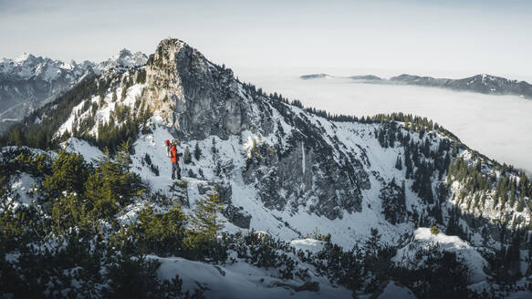 Deutschland, Bayern, Ammergauer Alpen, Teufelstattkopf, Tourist beim Bergwandern an einem Wintertag - RBF08065