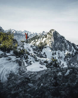 Deutschland, Bayern, Ammergauer Alpen, Teufelstattkopf, Tourist beim Bergwandern an einem Wintertag - RBF08066