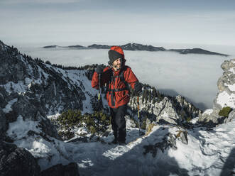 Germany, Bavaria, Ammergau Alps, Teufelstattkopf, Tourist hiking in mountains on winter day - RBF08068