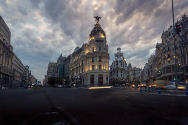 Niedriger Winkel des berühmten Metropolis-Gebäudes unter bewölktem Himmel am Abend in Madrid - ADSF20330