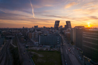Torres kio Business Area mit Wolkenkratzern, die das helle Licht des Sonnenuntergangs reflektieren, abends in Madrid - ADSF20348