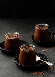 From above tasty chocolate mousse in glass jar arranged on table with chocolate powder dust - ADSF20437