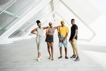 Group of cheerful African American stylish people standing together on the street looking at camera - ADSF20504