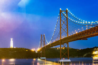 Portugal, Lisbon, Ponte 25 de Abril with Christ the King statue illuminated at night - EGBF00668