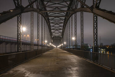 Germany, Hamburg, Diminishing perspective of Alte Harburger Elbbrucke bridge at night - RJF00856