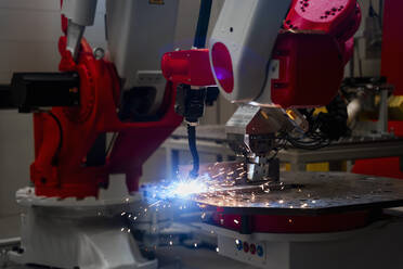 Nahaufnahme eines automatischen Roboterarms beim Schweißen von Metall in einer Fabrik - DIGF14347