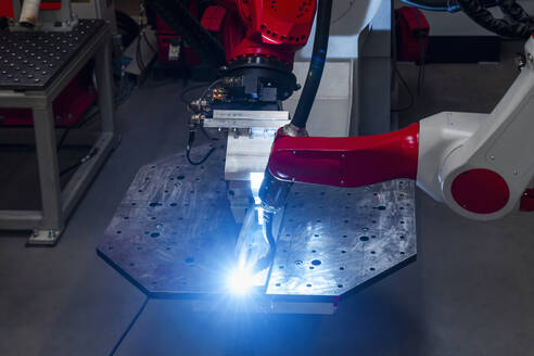 Nahaufnahme eines automatischen Roboterarms beim Schweißen von Metall in einer Fabrik - DIGF14350