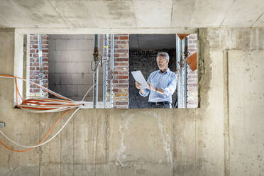Male architect using digital tablet while standing at construction site - PESF02572