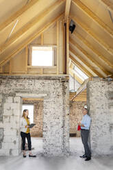 Expertise team having discussion while standing with social distance at construction site - PESF02585