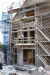 Reifes professionelles Team bei der Arbeit auf einem Balkon auf der Baustelle - PESF02620