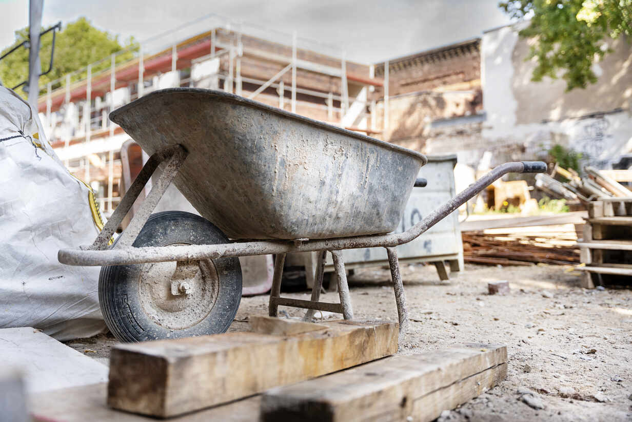 Wheelbarrow with construction material at construction site stock