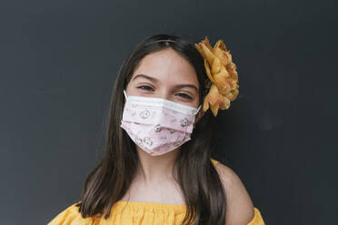 Nahaufnahme eines Mädchens mit Gesichtsmaske vor schwarzem Hintergrund - DSIF00293