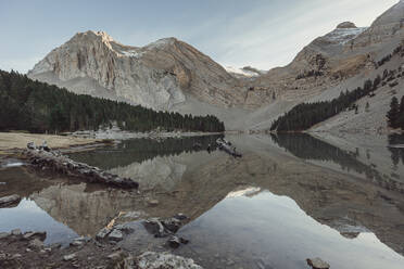 Spanien, Huesca, Berge spiegeln sich im See Ibon De Plan bei Sonnenuntergang - OCAF00623