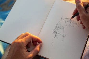 Man doing sketch in book - MAMF01582