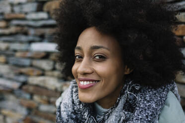 Lächelnde Afro-Frau vor Steinmauer - XLGF01040