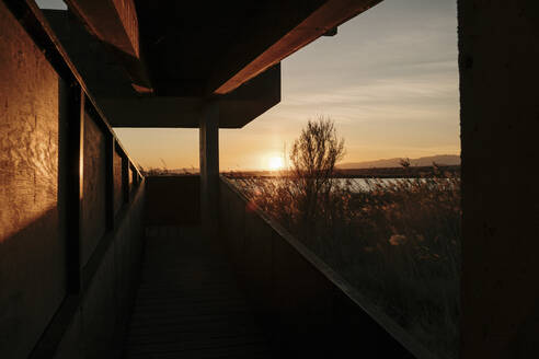 Spanien, Ebro-Delta, Sonnenuntergang über Landschaft mit Architekturelement - AFVF08086