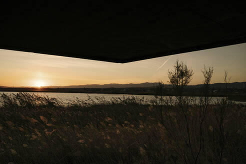 Spanien, Ebro-Delta, Sonnenuntergang über Landschaft mit Architekturelement - AFVF08090