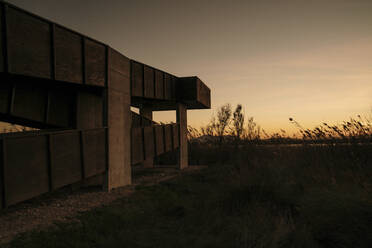 Spanien, Ebro-Delta, Sonnenuntergang über Landschaft mit Architekturelement - AFVF08091