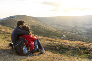 Young couple embracing while looking at sunset during vacations - WPEF03973