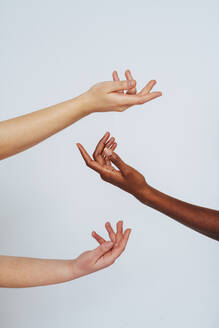 Women stretching hands toward each other against white background - OIPF00168