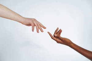 Freunde strecken einander die Hände entgegen vor weißem Hintergrund - OIPF00170