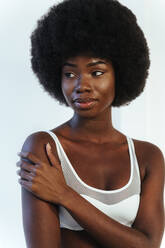 Young fashion model in lingerie contemplating against white wall - OIPF00198