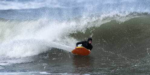 Älterer männlicher Brettsurfer beim Bodyboarden im Meer bei Broad Haven South, UK - ALRF01830