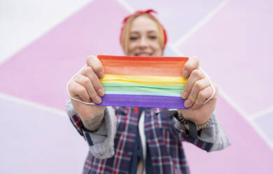 Woman holding multi colored face mask - JCCMF00944