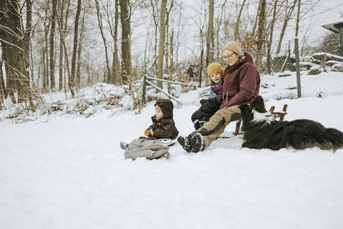 Frauen mit Töchtern und Border Collie verbringen das Wochenende zusammen im Winter im Schnee - DWF00566