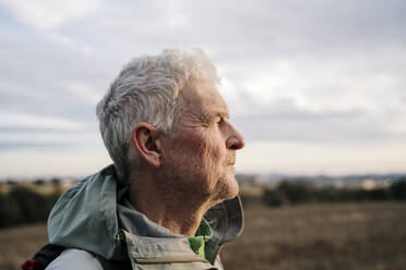 Senior male hiker looking away during sunset - AFVF08101