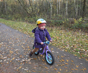 Cute girl riding bicycle on footpath - LAF02657