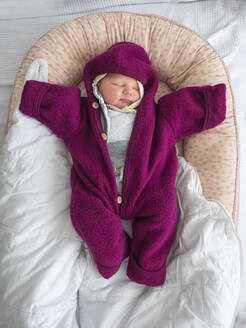 Niedliche Baby-Mädchen in warmer Kleidung schlafen auf dem Bett zu Hause - LAF02658