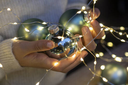 Hands of little girl holding Christmas ornaments - LBF03322