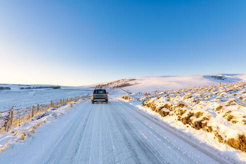 Vereinigtes Königreich, Schottland, East Lothian, Wintersonnenaufgang über einer Straße durch eine ländliche Landschaft - SMAF01984