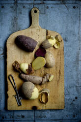 Different varieties of potatoes on rustic cutting board - ASF06709