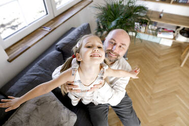Glücklicher Vater spielt mit seiner Tochter zu Hause - KMKF01478