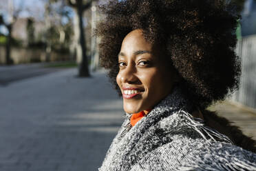 Glückliche junge Afro-Frau auf der Straße an einem sonnigen Tag - XLGF01070
