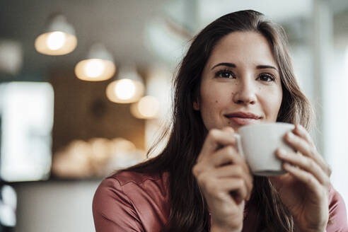 Unternehmerin mit Kaffeetasse und Tagträumen in einem Café - JOSEF03110