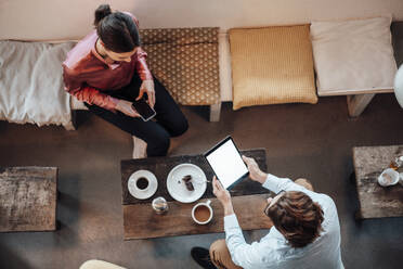 Businesswoman having meeting with male coworker while sitting in cafe - JOSEF03115