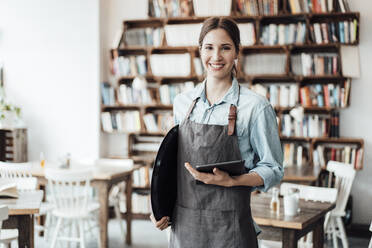 Lächelnde Unternehmerin mit digitalem Tablet und Tablett in einem Café - JOSEF03124