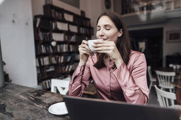 Weibliche Fachkraft riecht Kaffee am Tisch im Café - JOSEF03149