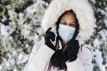 Mature woman with protective face mask in park during pandemic - EBBF02323