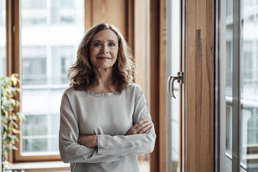 Confident businesswoman with arms crossed at office - JOSEF03347