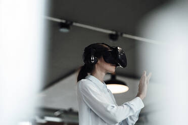 Businesswoman with virtual reality simulator at office - JOSEF03403