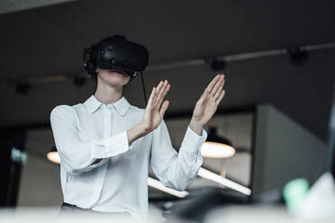 Businesswoman using virtual reality simulator in creative office - JOSEF03404