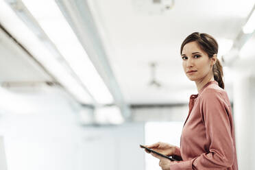 Selbstbewusste Geschäftsfrau mit digitalem Tablet im Büro - JOSEF03411