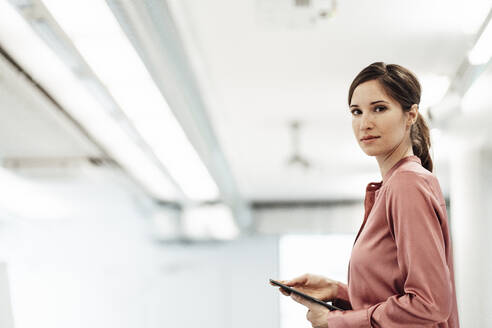 Confident businesswoman with digital tablet in office - JOSEF03411