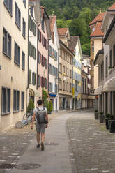 Forscher mit Rucksack auf der Storchengasse in der Altstadt von Chur, Schweiz - TAMF02818